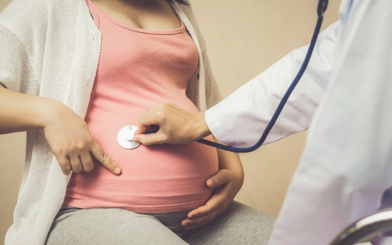 lekarz bada brzuch kobiety w ciąży